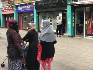محجبات ومنقبات تسرن في شارع في دائرة Popar&Limehouse